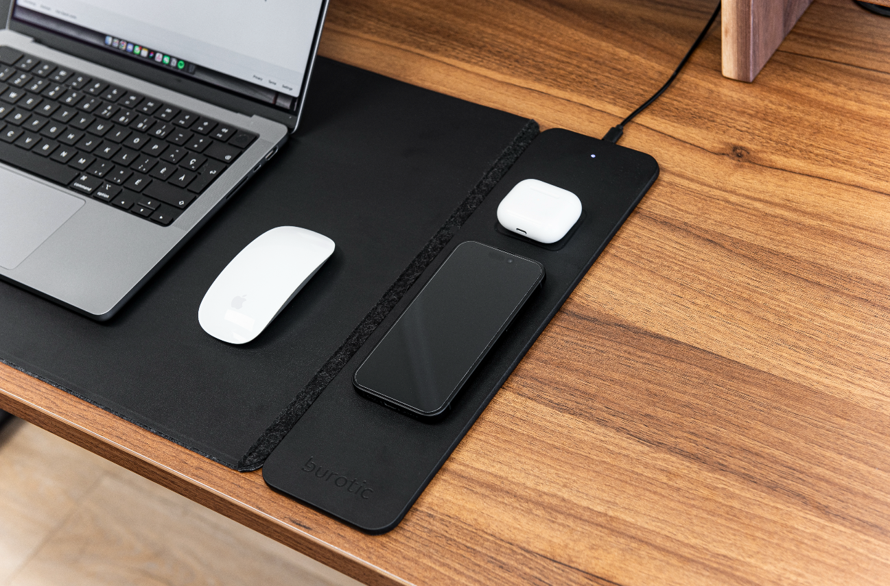Wireless charging desk pad arranged with everyday devices on a clean desk
