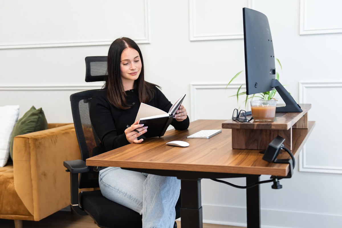 Woman seated in a black chair with a clearly visible mesh backrest