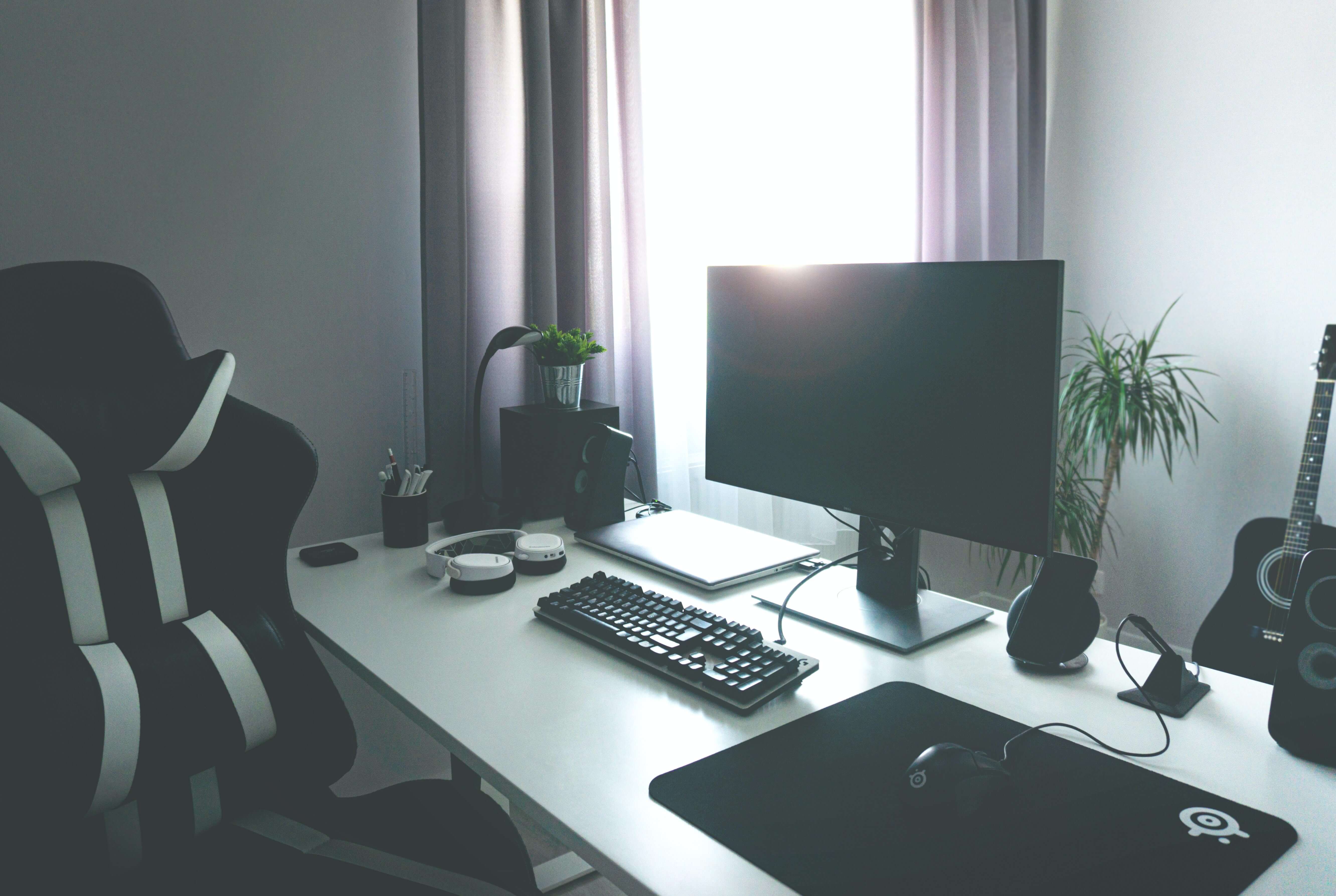 burotic bureau blanc ajustable avec chaise ergonomique et accessoires. Souris avec tapis de souris, clavier et grand écran.