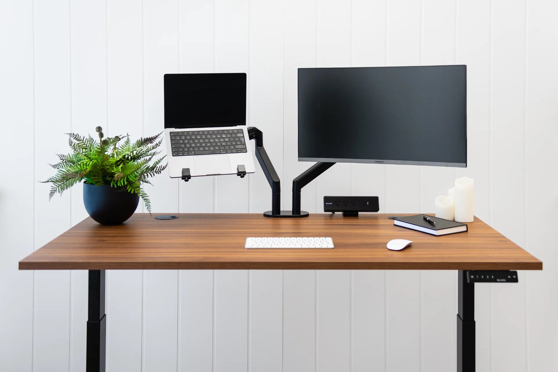 Laptop and external monitor mounted on separate adjustable arms above a walnut desk