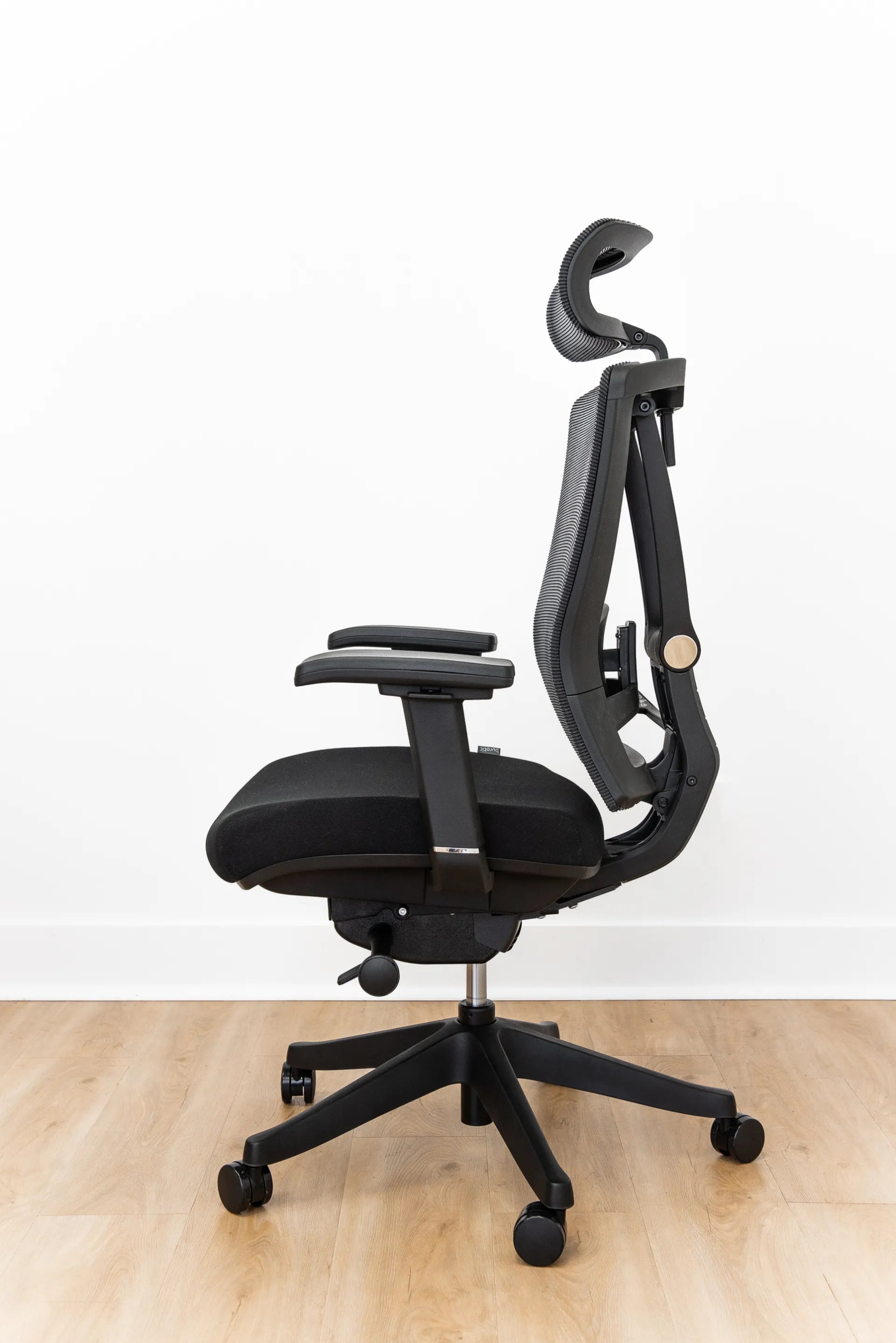 Side view of a black Burotic ergonomic chair reclined to show its tilt movement