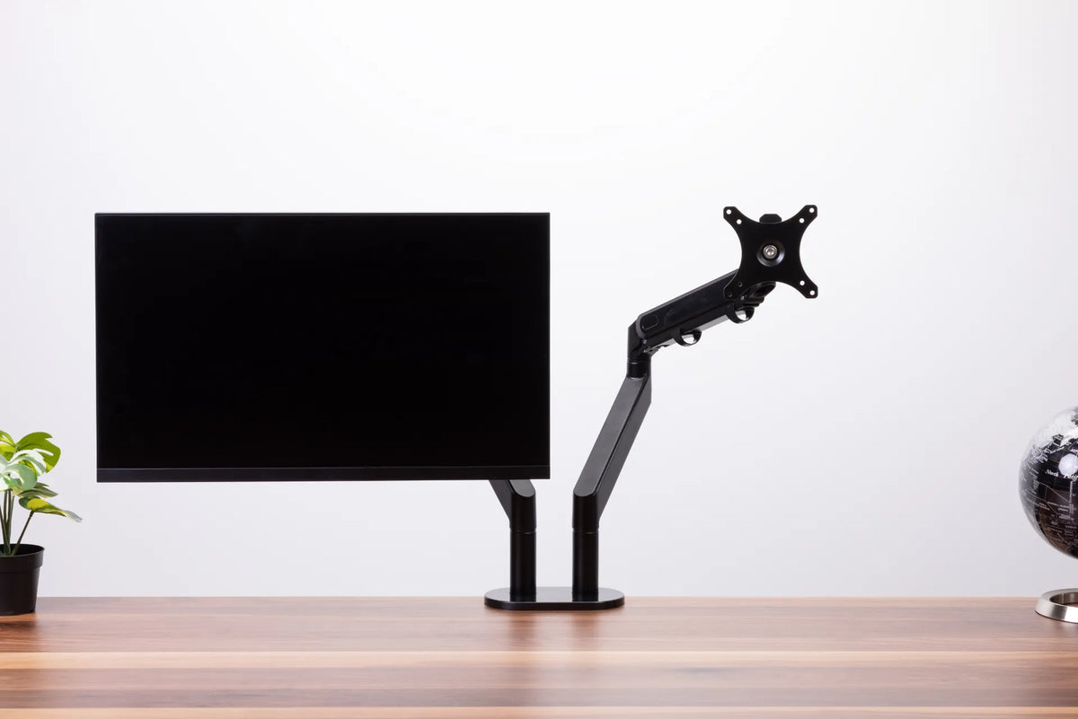 Black monitor on a dual monitor arm with the second VESA mounting plate visible against a white background