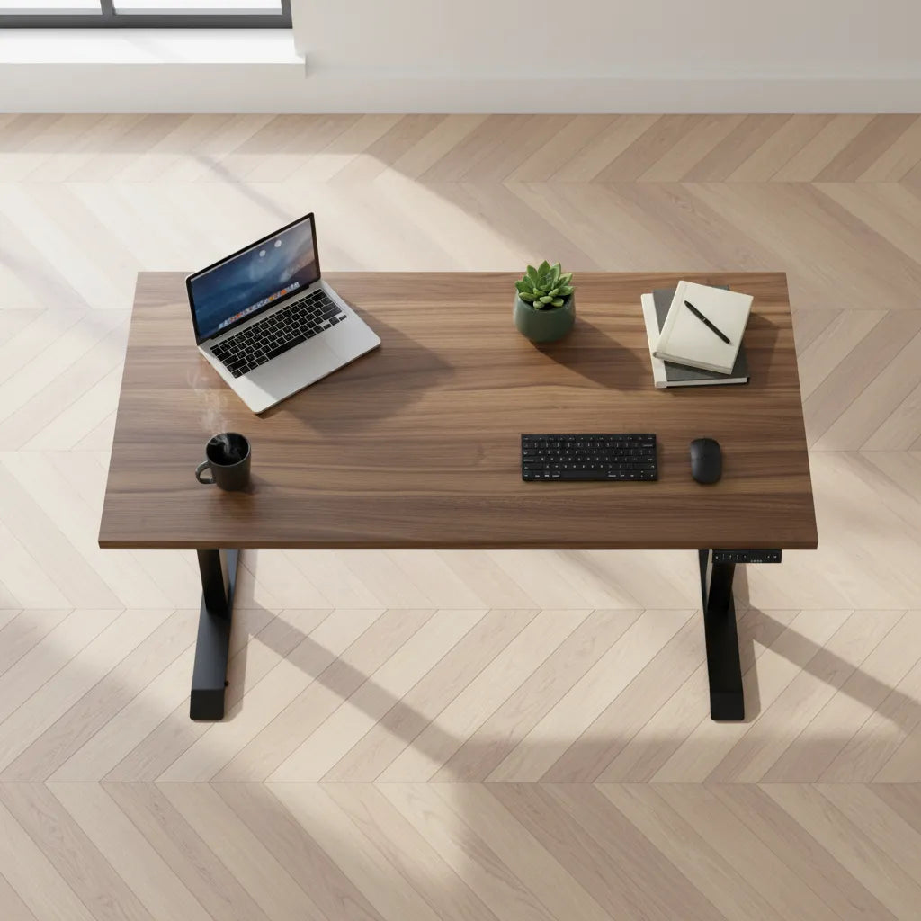 Top view of a walnut adjustable desk on a light wood floor