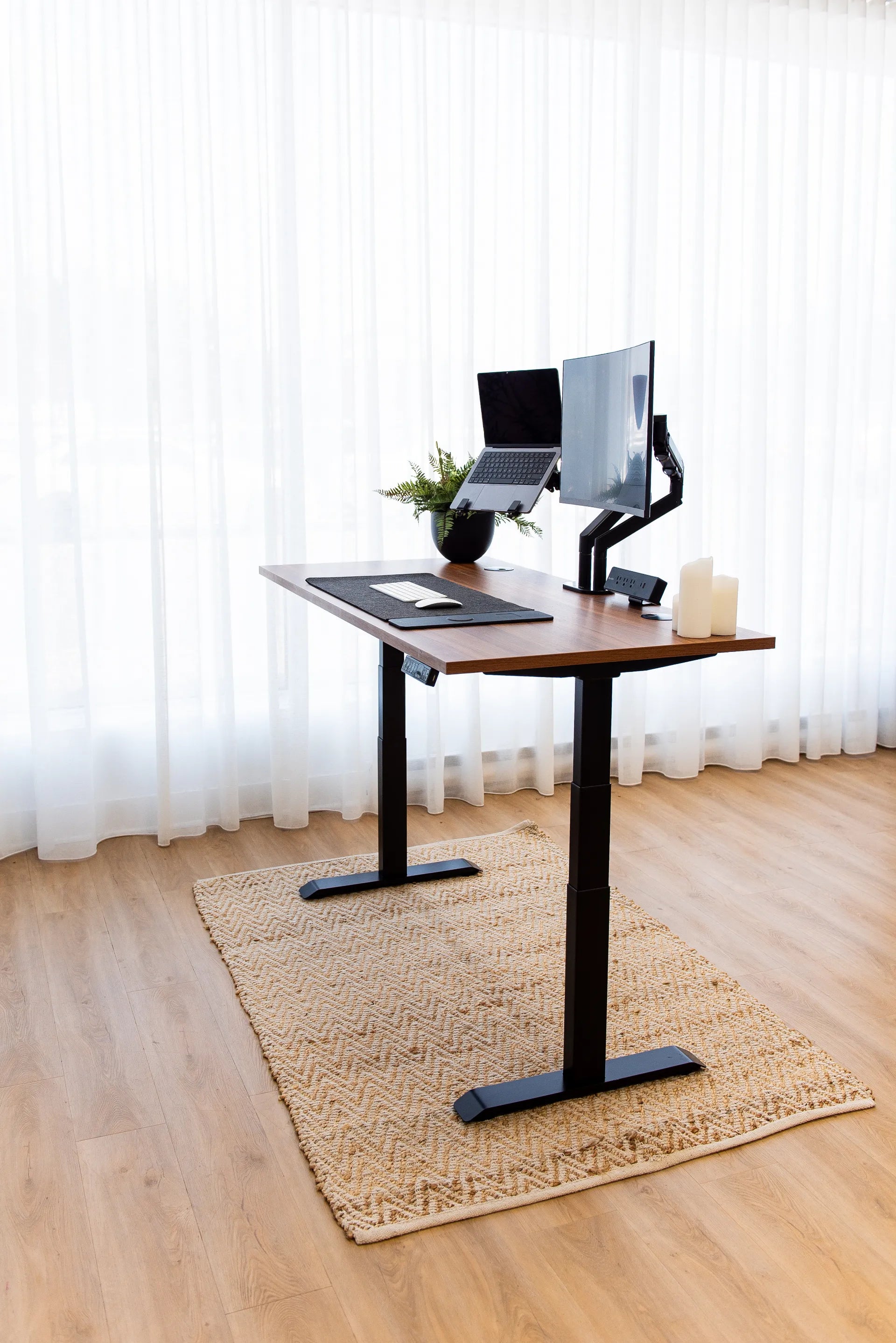 Walnut Burotic standing desk with monitor arm, laptop stand, desk mat, keyboard, mouse and power bar